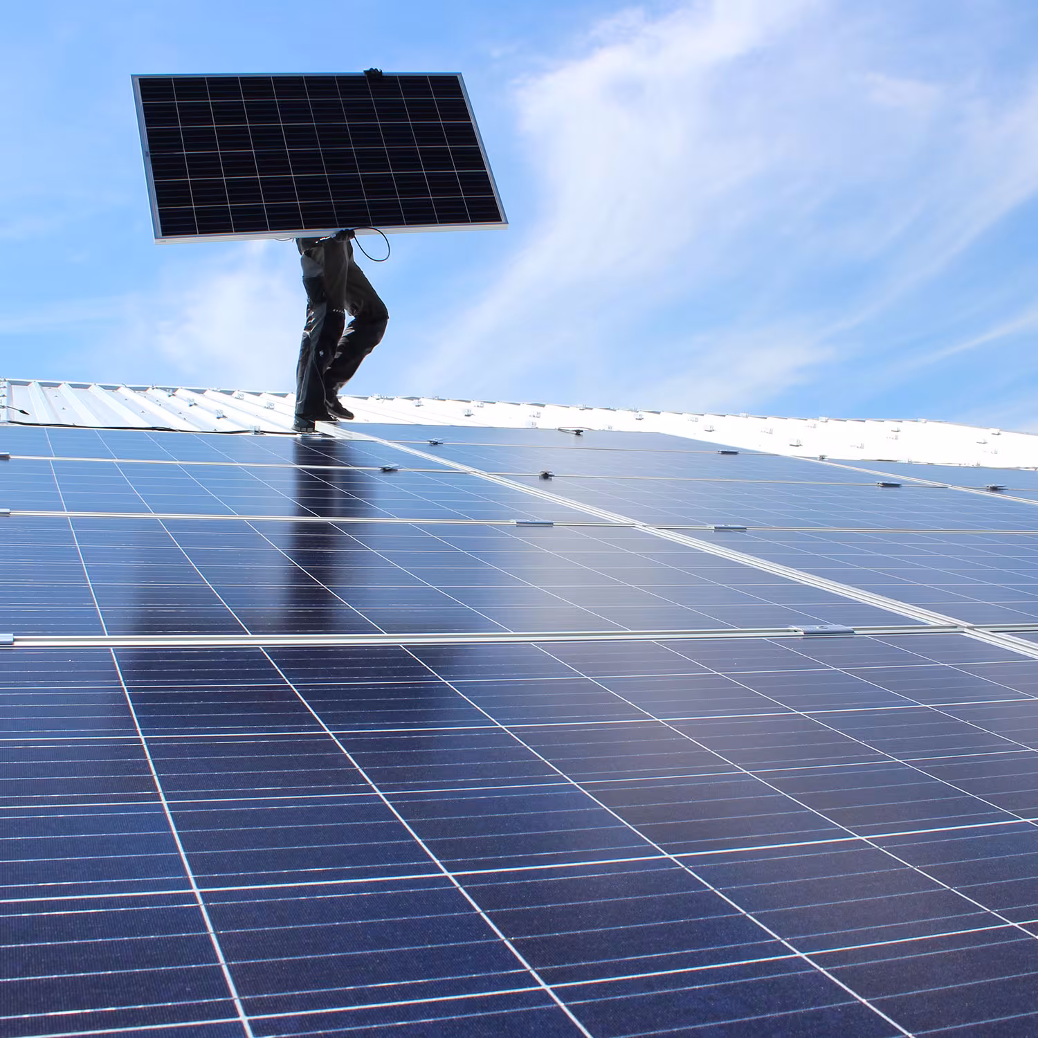 Holtz & Partner beim Installieren eines Solarmoduls auf einem Dach